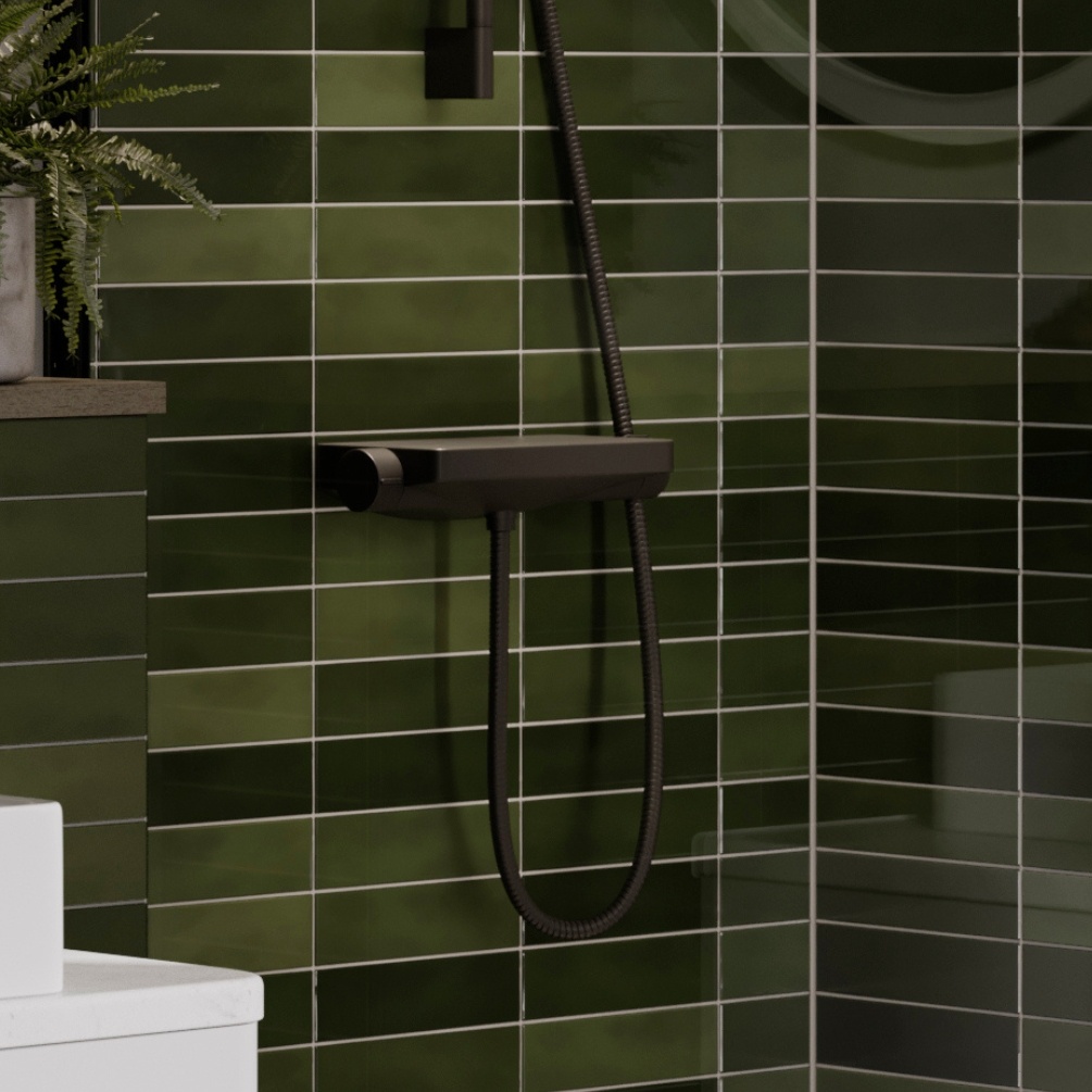 Lifestyle image of the Britton Hoxton Matt Black Thermostatic Shower Valve mounted in an enclosed bathroom with green tiled walls